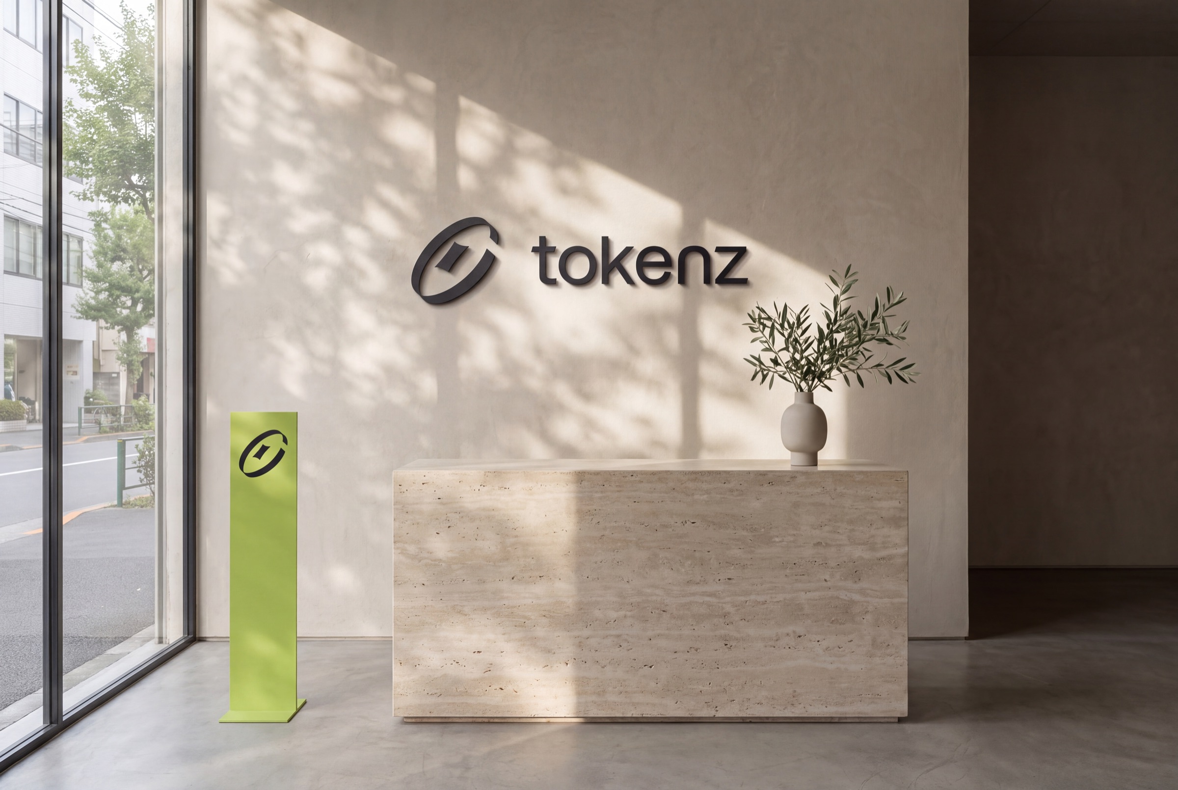 Office reception with the dimensional Tokenz lockup on a limestone wall